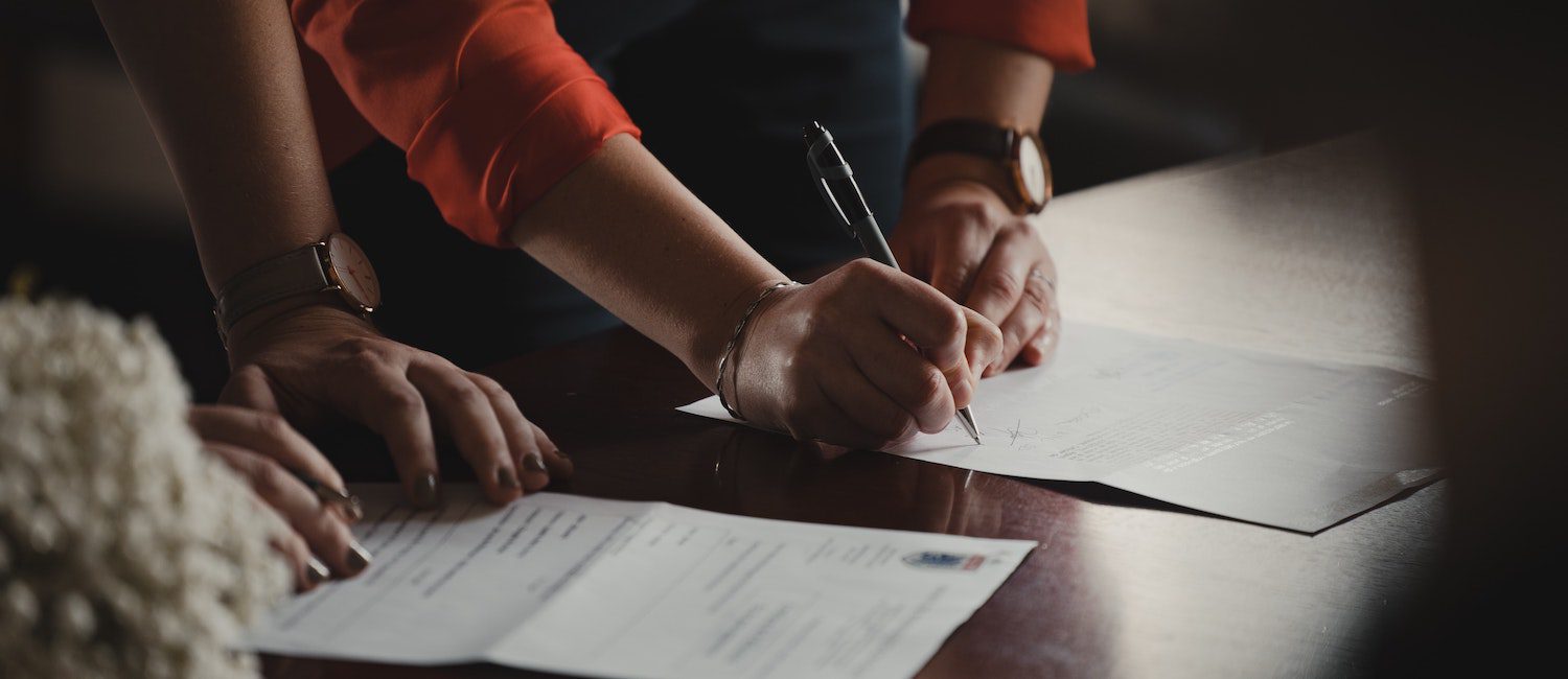 Two people signing a contract