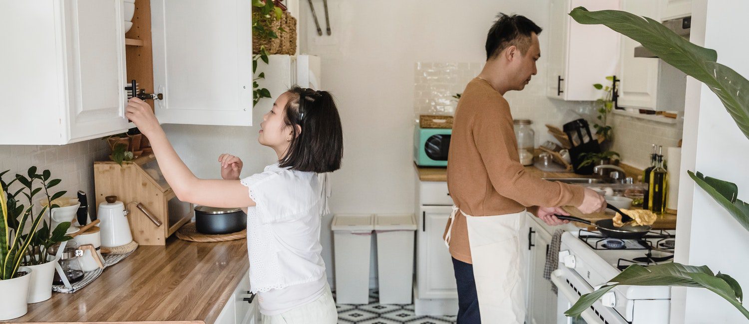 couple cleaning up their small kitchen
