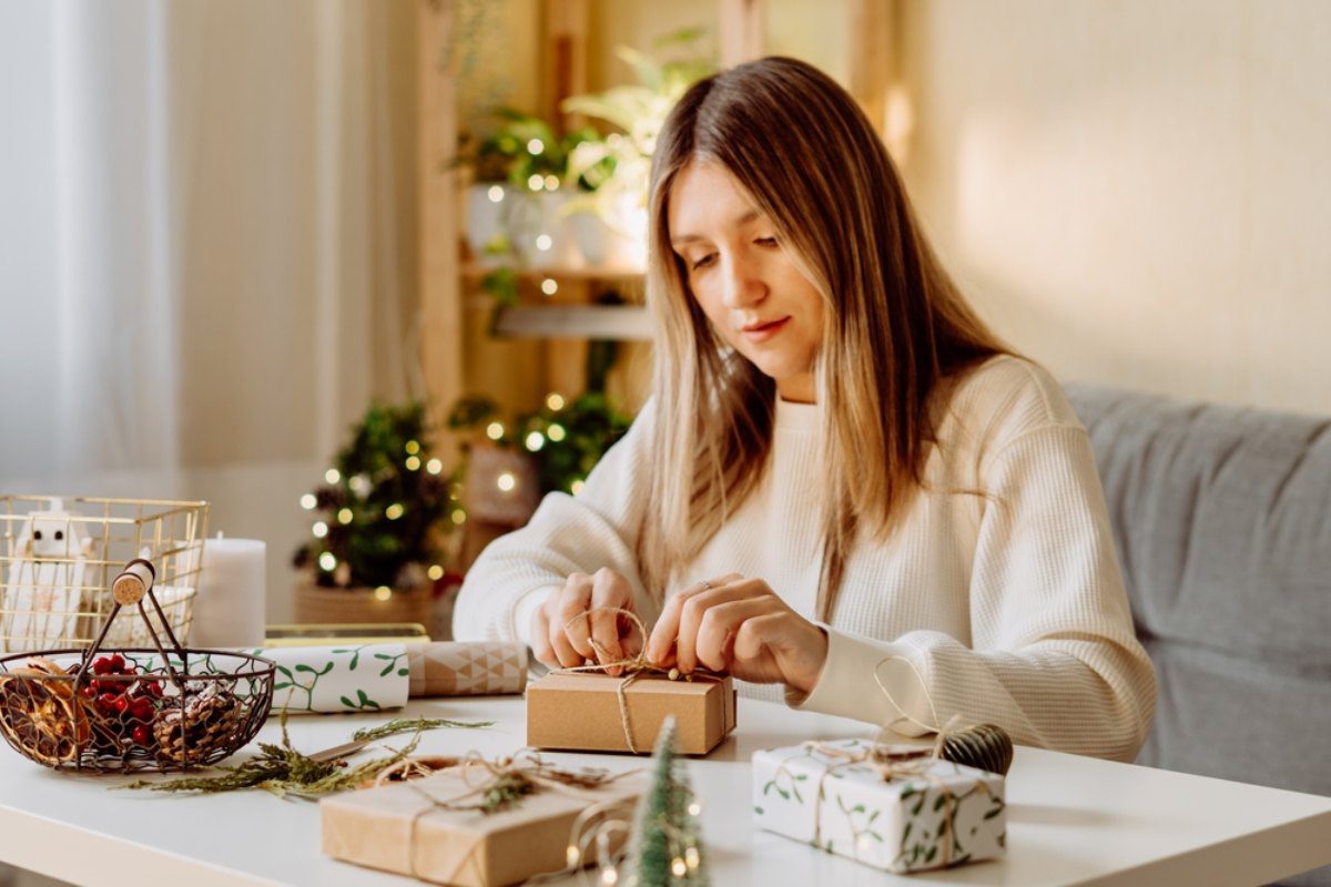 Easy gifts to make at home - a woman wrapping presents inside her apartment